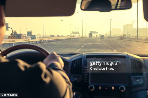 inside the car, driving on the highway at sunset in dubai uae. - window display stock-fotos und bilder