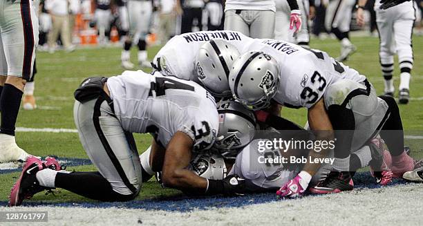 Safety Michael Huff of the Oakland Raiders is mobbed by his teammates after intercepting a pass on the goalline intended for wide receiver Jacoby...