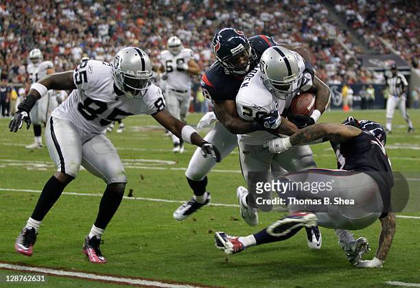 Running back Darren McFadden of the Oakland Raiders is gang tackled by the Houston Texans on October 9, 2011 at Reliant Stadium in Houston, Texas....