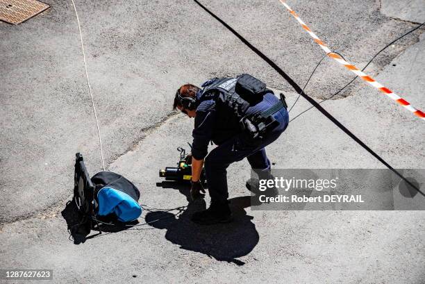 Démineur avec son matériel inspectant un sac suspect avec un robot démineur après qu'un homme ait menacé des passants avec une arme à feu à quelques...