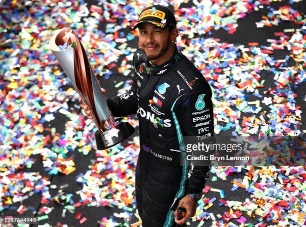 Race winner Lewis Hamilton of Great Britain and Mercedes GP celebrates winning a 7th F1 World Drivers Championship on the podium during the F1 Grand...