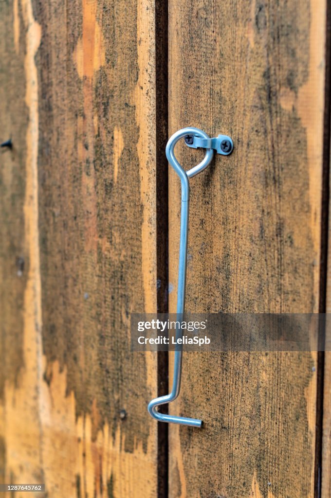 Steel hook on a wooden door, close-up photo