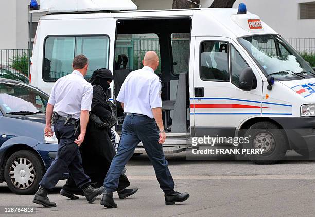 French Muslim woman, wife of Lies Hebbadj , is escorted by policemen upon her arrival at Reze police station, western France, on October 7, 2011 one...