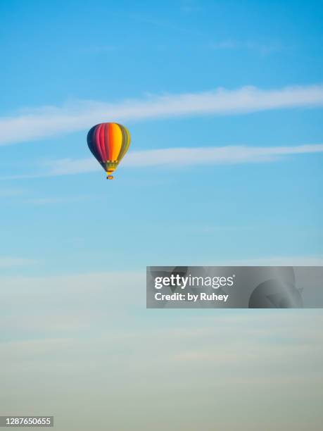 hot air balloon in a blue sky with some soft cloud - hot air balloon imagens e fotografias de stock