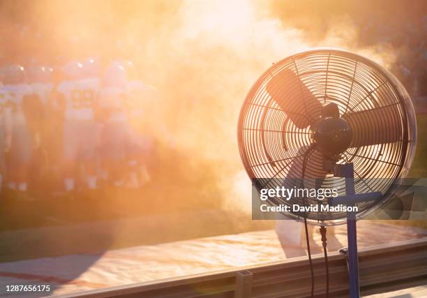 cooling fan on sidelines of football game - luchtvochtigheid stockfoto's en -beelden