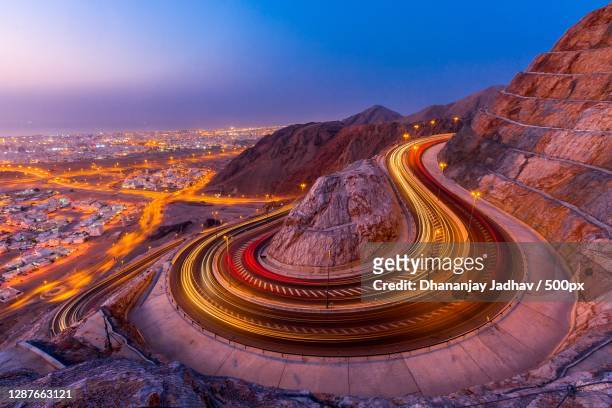 high angle view of light trails on road at night,muscat,oman - masqat oman stockfoto's en -beelden