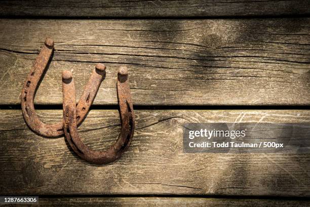 close-up of rusty metal on wooden table - horseshoe luck stock pictures, royalty-free photos & images