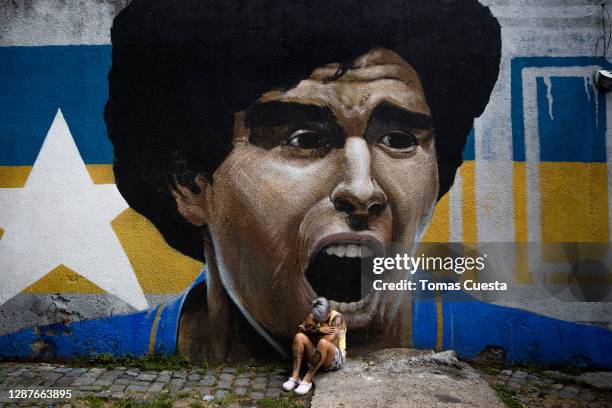 Argentina footballer of Boca Junior's women's team Yamila Rodriguez cries in front of a graffiti of Diego Maradona after the news of his death was...