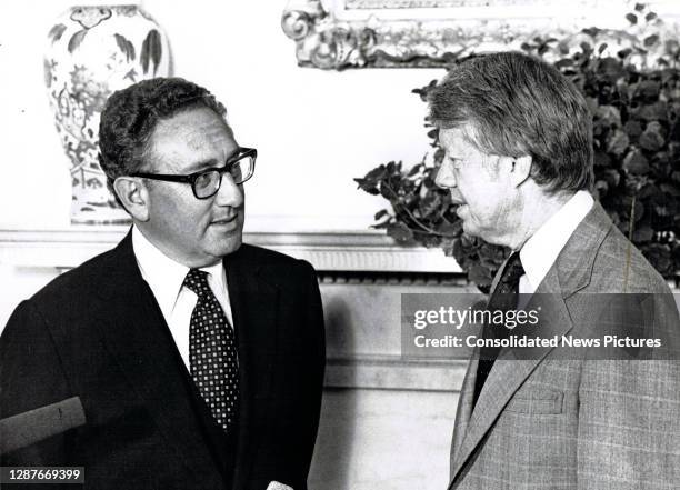 Former US Secretary of State Henry Kissinger and President Jimmy Carter talk in the White House's Oval Office, Washington DC, August 15, 1977.