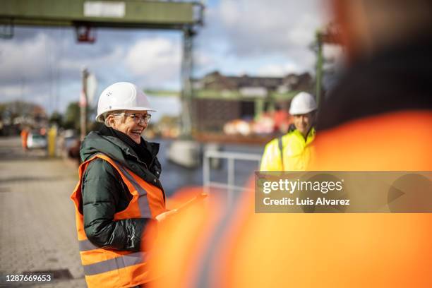 senior manager having meeting with team at large commercial dock - bright smile stock pictures, royalty-free photos & images