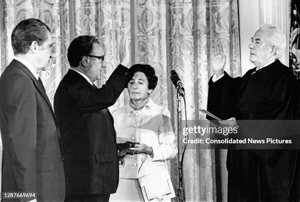 As US President Richard Nixon watches, Henry Kissinger is sworn-in, by Chief Justice of the US Warren E Burger , as the 56th US Secretary of State,...