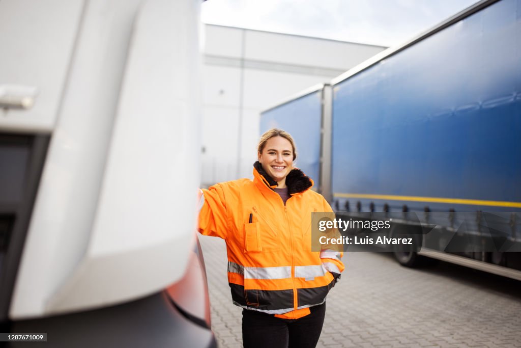 Female transport engineer standing by the truck outdoors