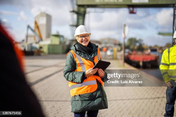 smiling manager having a meeting with dock workers - scheepswerf stockfoto's en -beelden