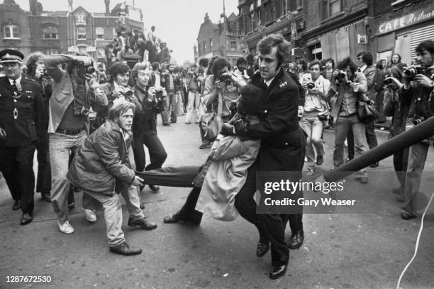 Photographers gather to take shots as a police officer holds a demonstrator in a headlock and drags him away, during a National Front march in...