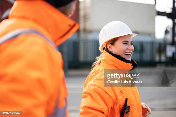 smiling female engineer at the shipyard - berufliche beschäftigung stock-fotos und bilder