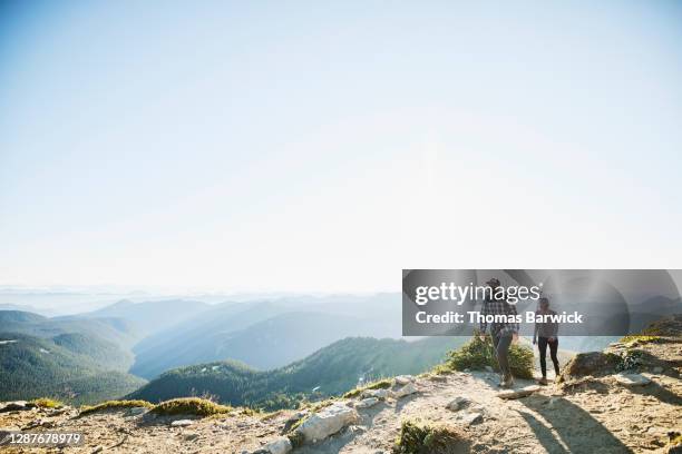 couple wearing protective face masks on sunrise hike in mountains - vacations covid stock pictures, royalty-free photos & images