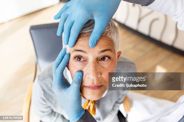 senior patient having an eye exam at ophthalmologist's office - eye problems stock pictures, royalty-free photos & images