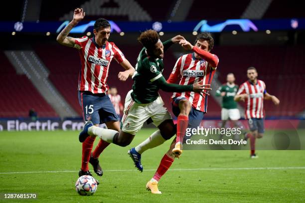 Ze Luis of Lokomotiv Moscow is challenged by Jose Gimenez and Stefan Savic of Atletico de Madrid during the UEFA Champions League Group A stage match...