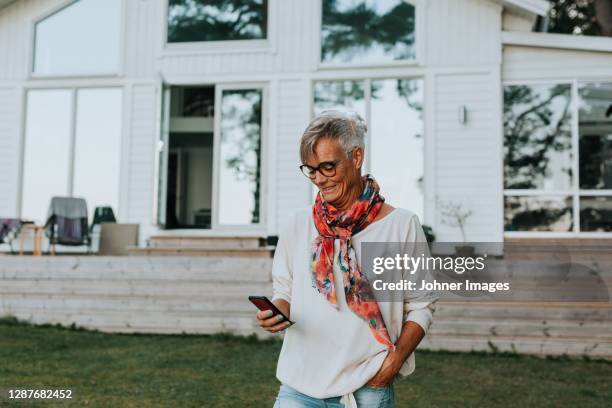smiling woman using cell phone - sjaal stockfoto's en -beelden