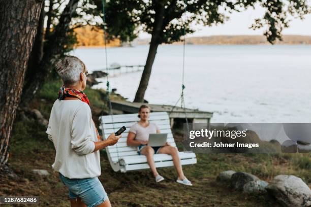 woman in garden talking to adult son - cottage stockfoto's en -beelden