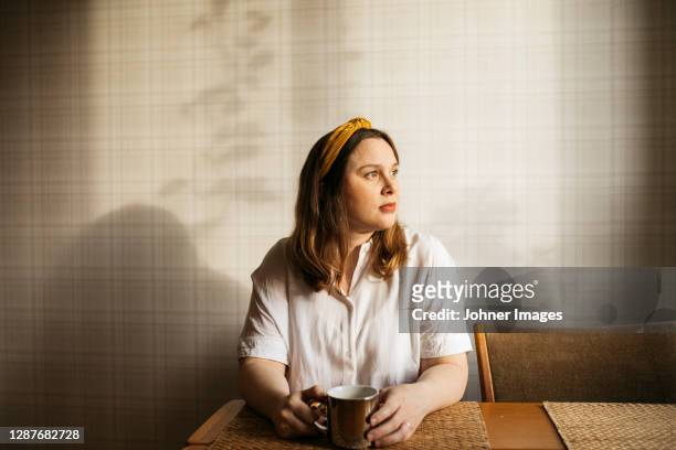 pregnant woman looking out of window - loneliness bildbanksfoton och bilder