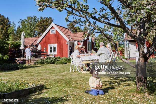toddler playing in garden - huisje stockfoto's en -beelden