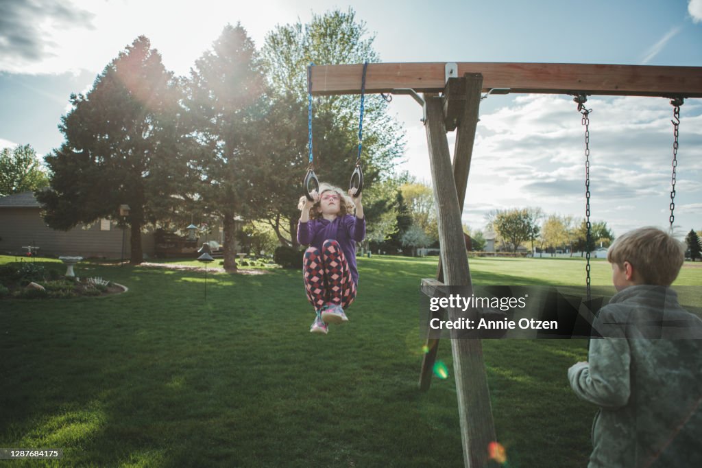 Kids playing on a backyard swing set