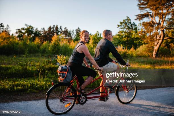 couple riding tandem bike - tandem bicycle stock pictures, royalty-free photos & images