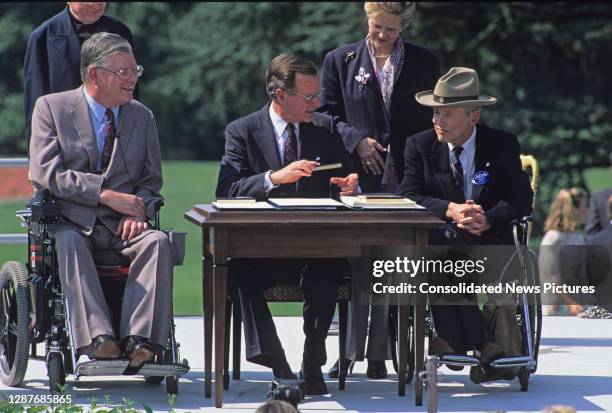 During a ceremony on the White House's South Lawn, US President George HW Bush signs ceremony of the Americans with Disabilities Act of 1990 ,...