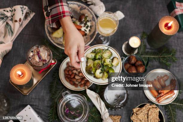 hand holding plate with brussel sprouts over christmas table - johner christmas foto e immagini stock