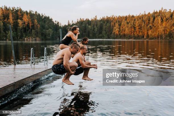 friends jumping into lake - bathing jetty stock pictures, royalty-free photos & images