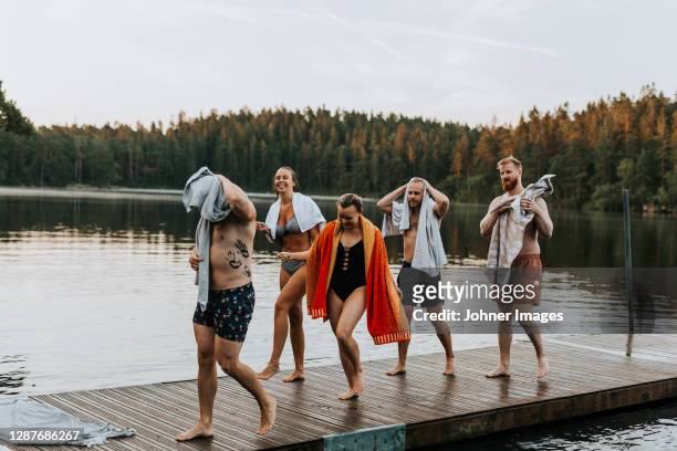 smiling friends walking on jetty - bathing jetty stock pictures, royalty-free photos & images