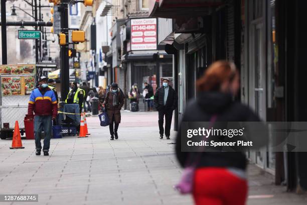 People walk through downtown Newark as the city experiences a rise in Covid-19 cases on November 25, 2020 in Newark, New Jersey. Newark residents...