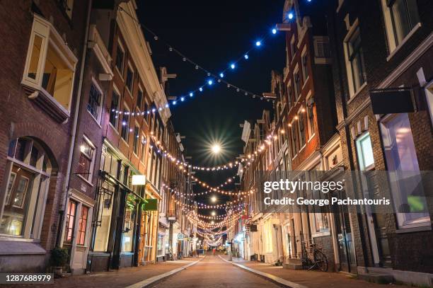 low angle view of street with lamps in amsterdam at night - christmas scenes stockfoto's en -beelden