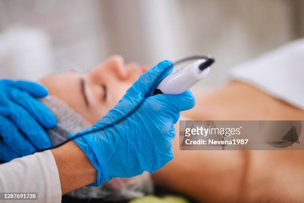 young woman get face treatments at beauty clinic - electrolysis stock pictures, royalty-free photos & images