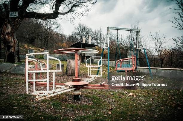 rusty playground roundabout (merry-go-round) - children's playground in tavush province, along the armenian-azerbaijan border. - verlaten slechte staat stockfoto's en -beelden