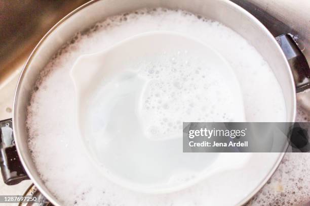 dirty dishes soaking in kitchen sink household chores - dirty pan stock pictures, royalty-free photos & images