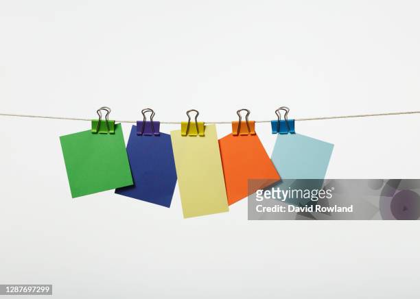 coloured cards hanging from a line with bulldog clips - bulldog clip imagens e fotografias de stock