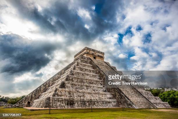 kukulkan pyramid at chichen itza archaeological site against dramatic sky. - azteca fotografías e imágenes de stock