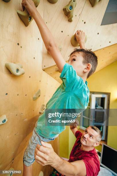 boy learns free climbing with his father - bouldering stock pictures, royalty-free photos & images