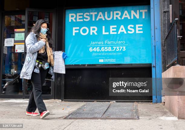 Person walks by a sign that reads, "restaurant for lease" outside a restaurant in Hell's Kitchen as the city continues the re-opening efforts...