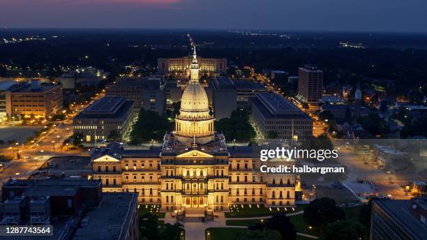 ミシガン州議会議事堂のドローンビューが夜間にライトアップ - michigan state capitol ストックフォトと画像