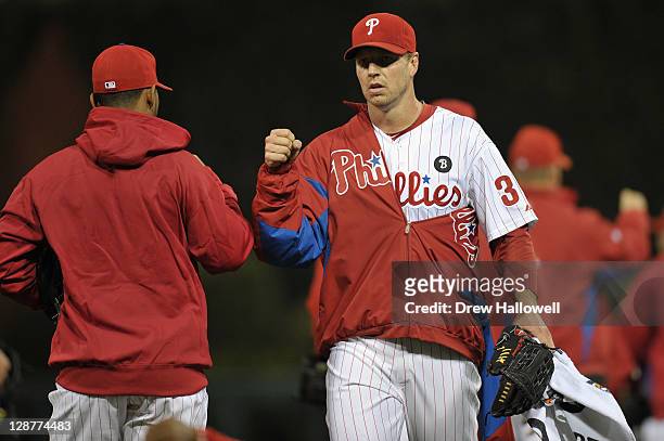 Roy Halladay of the Philadelphia Phillies greets a teammate as he gets set to pitch against the St. Louis Cardinals during Game Five of the National...