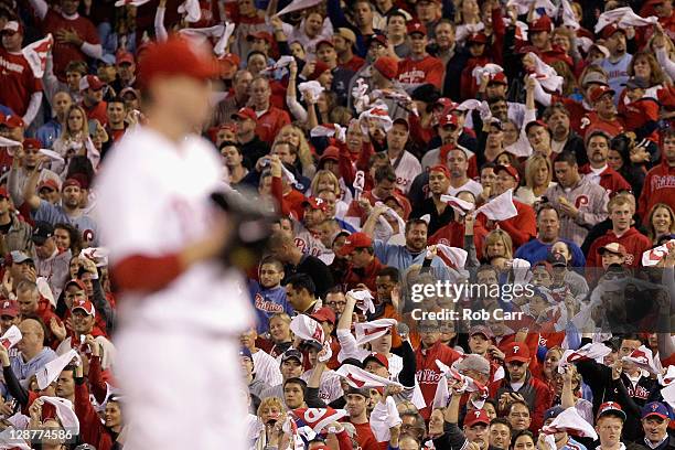 Fans cheer and wave towels as Roy Halladay of the Philadelphia Phillies gets set to throw a pitch in the top of the first inning against the St....