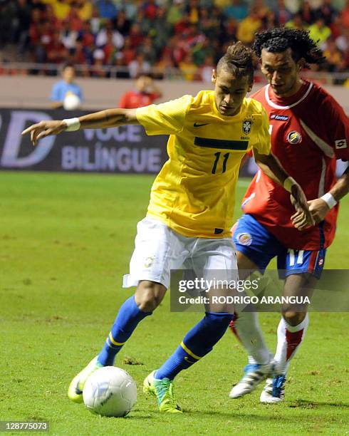 Brazilian player Santos Junior Neymar and Costa Rica's Michael Barrantes vie for the ball during a friendly match on October 7, 2011 on San Jose,...