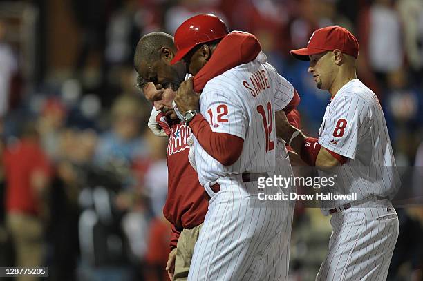 Ryan Howard of the Philadelphia Phillies is assisted off of the field after he was hurt on the last play of the game as the Phillies lost 1-0 against...