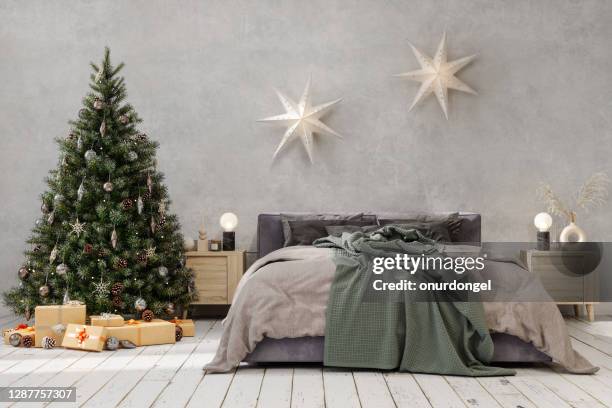 arbre de noël avec des ornements et des meubles de lit avec la literie grise de couleur dans la chambre à coucher - linge de lit photos et images de collection