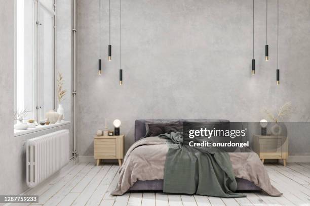 interni della camera da letto con coperta verde sul letto, luci pendenti, pavimento in parquet e sfondo della parete di colore grigio - loft interior foto e immagini stock