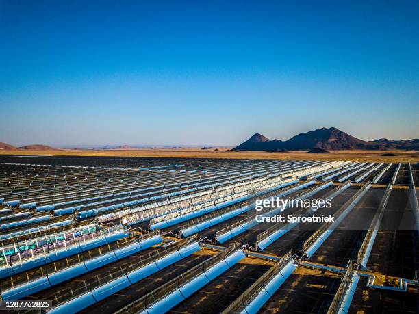 high view of parabolic trough collectors at the xina solar plant in south africa - solar power station stock pictures, royalty-free photos & images