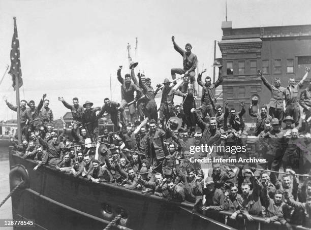 Group of American soldiers wave heartily from the deck of a ship transporting them to the fighting in France, during World War I, 1917.